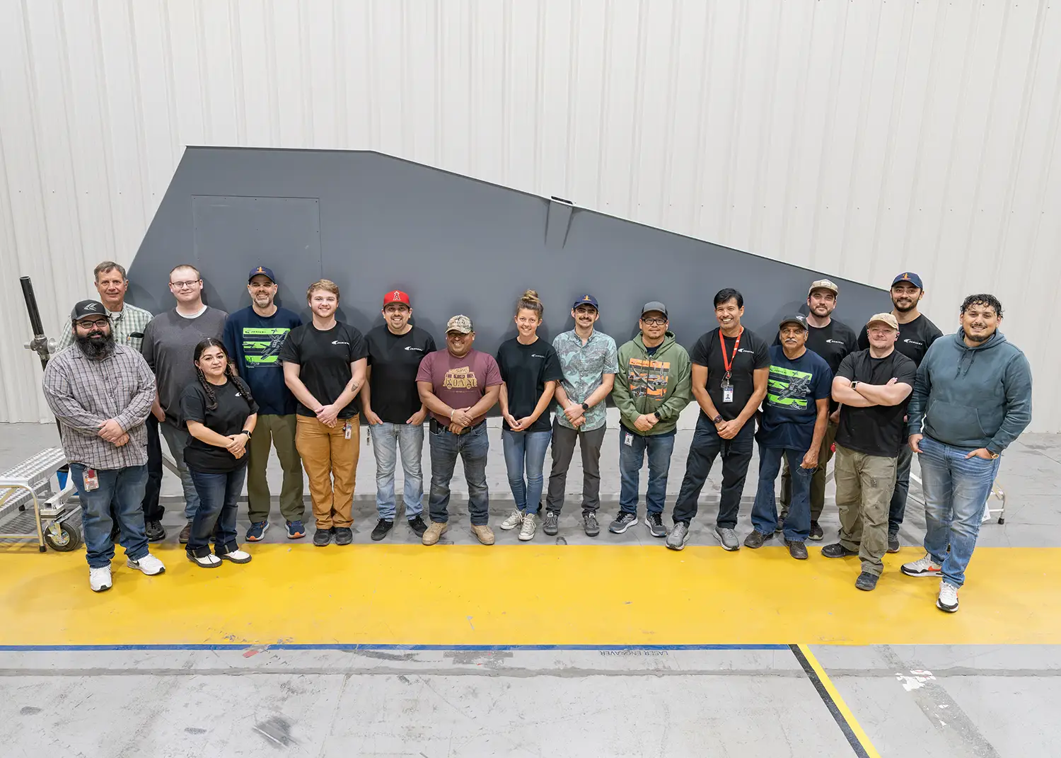 Janicki Marine Team Poses In Front of Composite Part