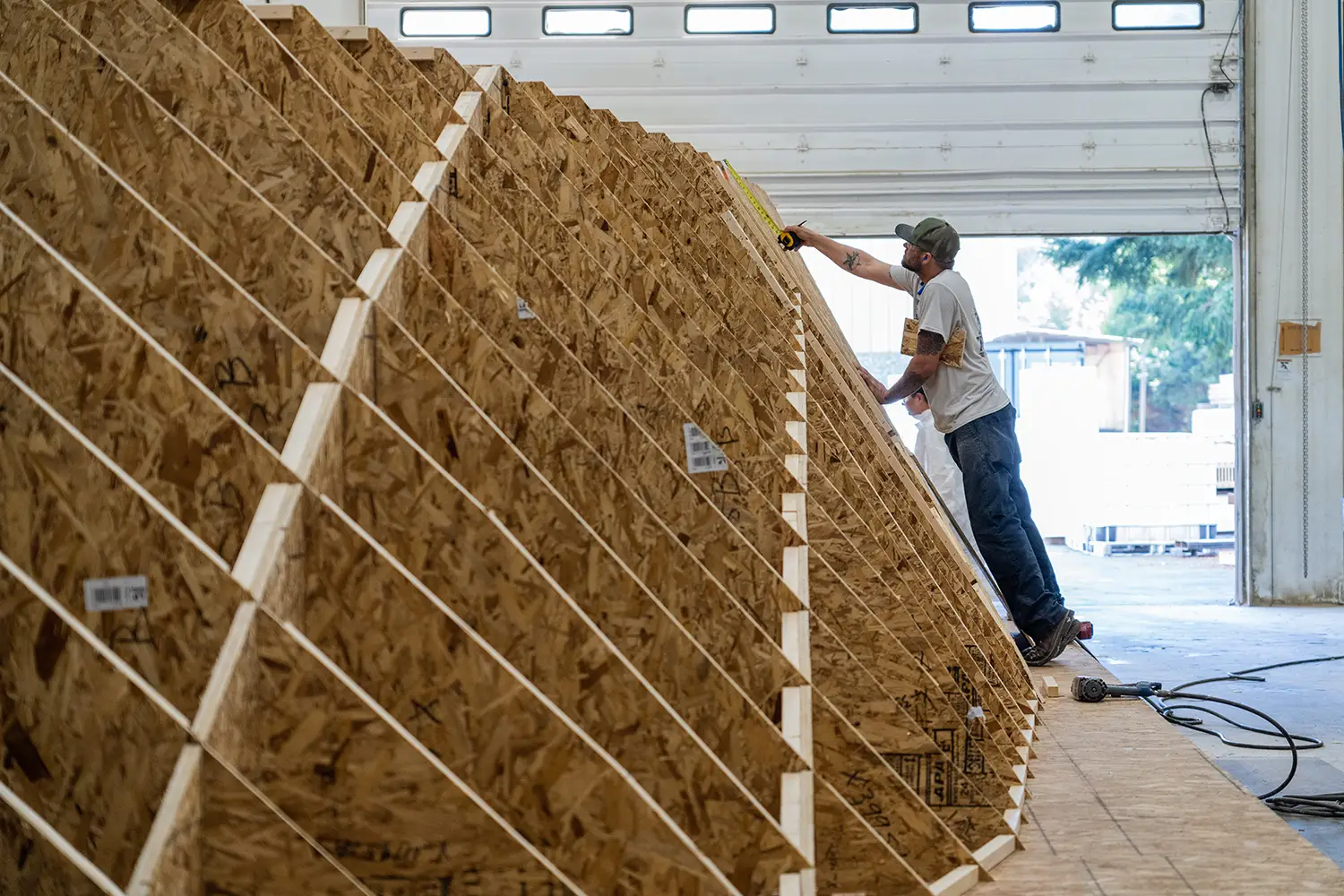 Employee measuring wooden structure