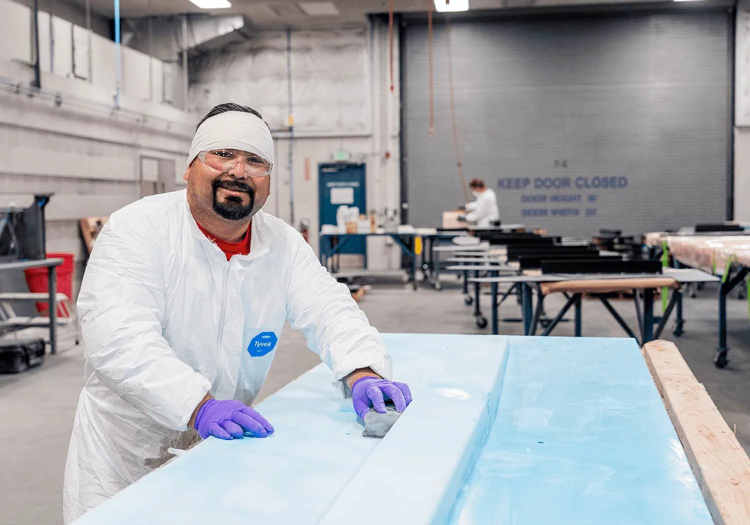 Employee smiling while sanding tool